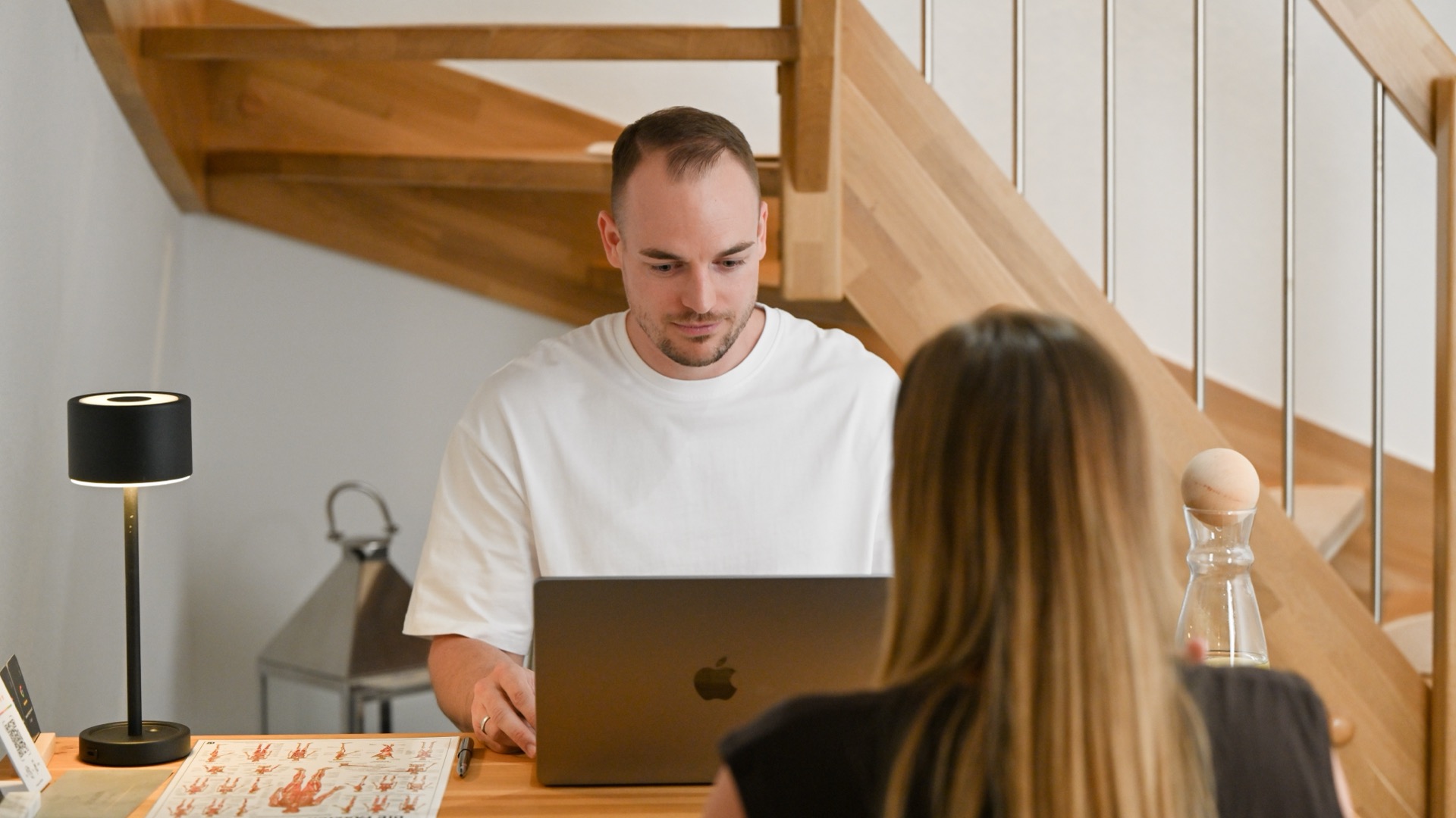 Gespräch am Tisch mit Laptop und Muskelübersicht